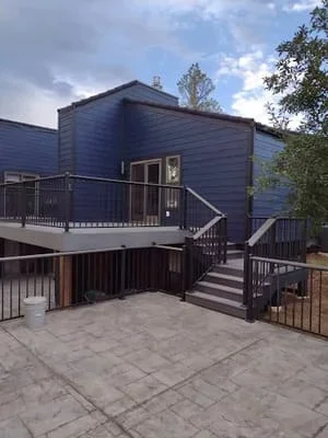 Multi-level composite deck and patio with black railings and stairs in Littleton