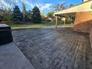 Stamped concrete patio with slate texture pattern and pergola shade structure