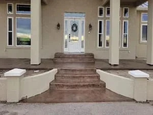 Brick staircase entry with curved concrete planters on either side